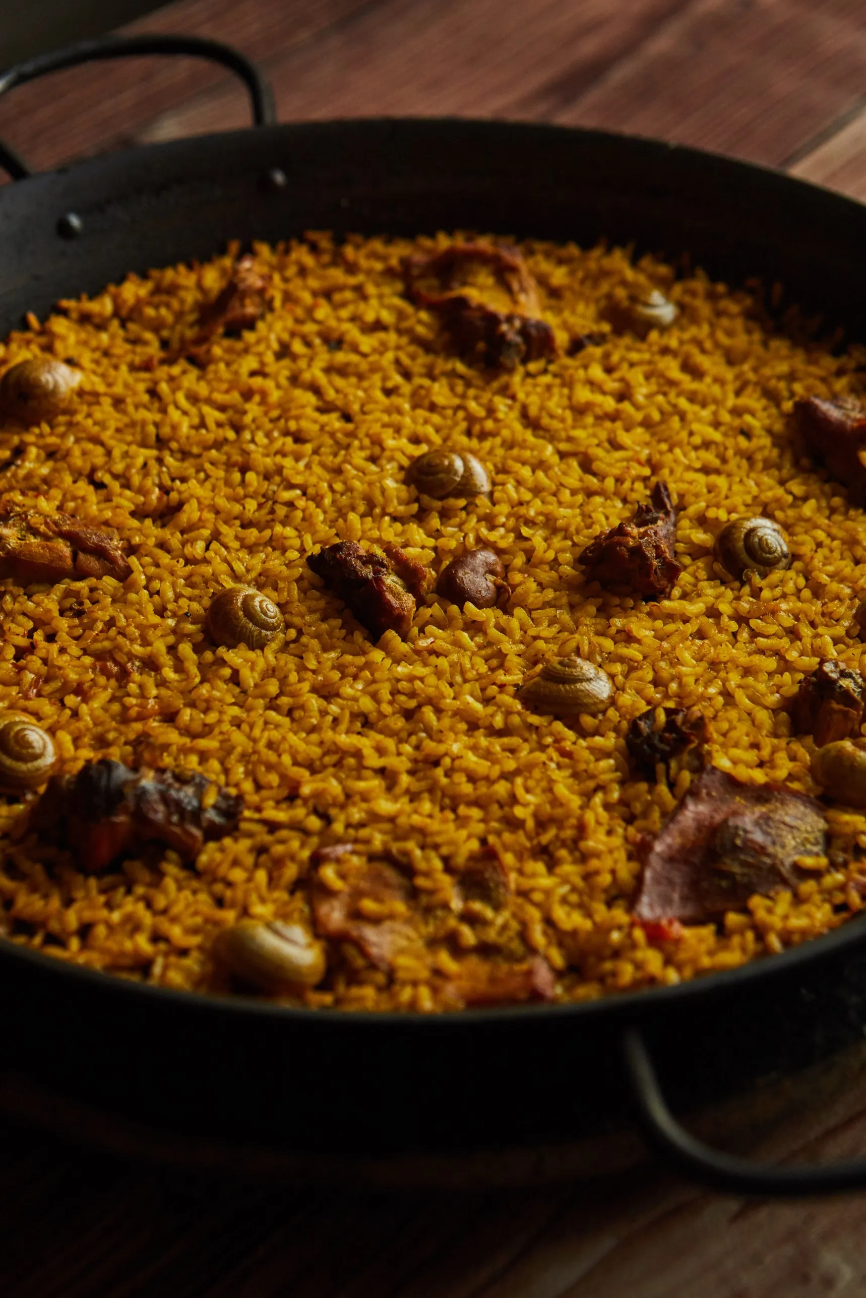 Arroz de conejo y caracoles recién hecho en paellera de hierro