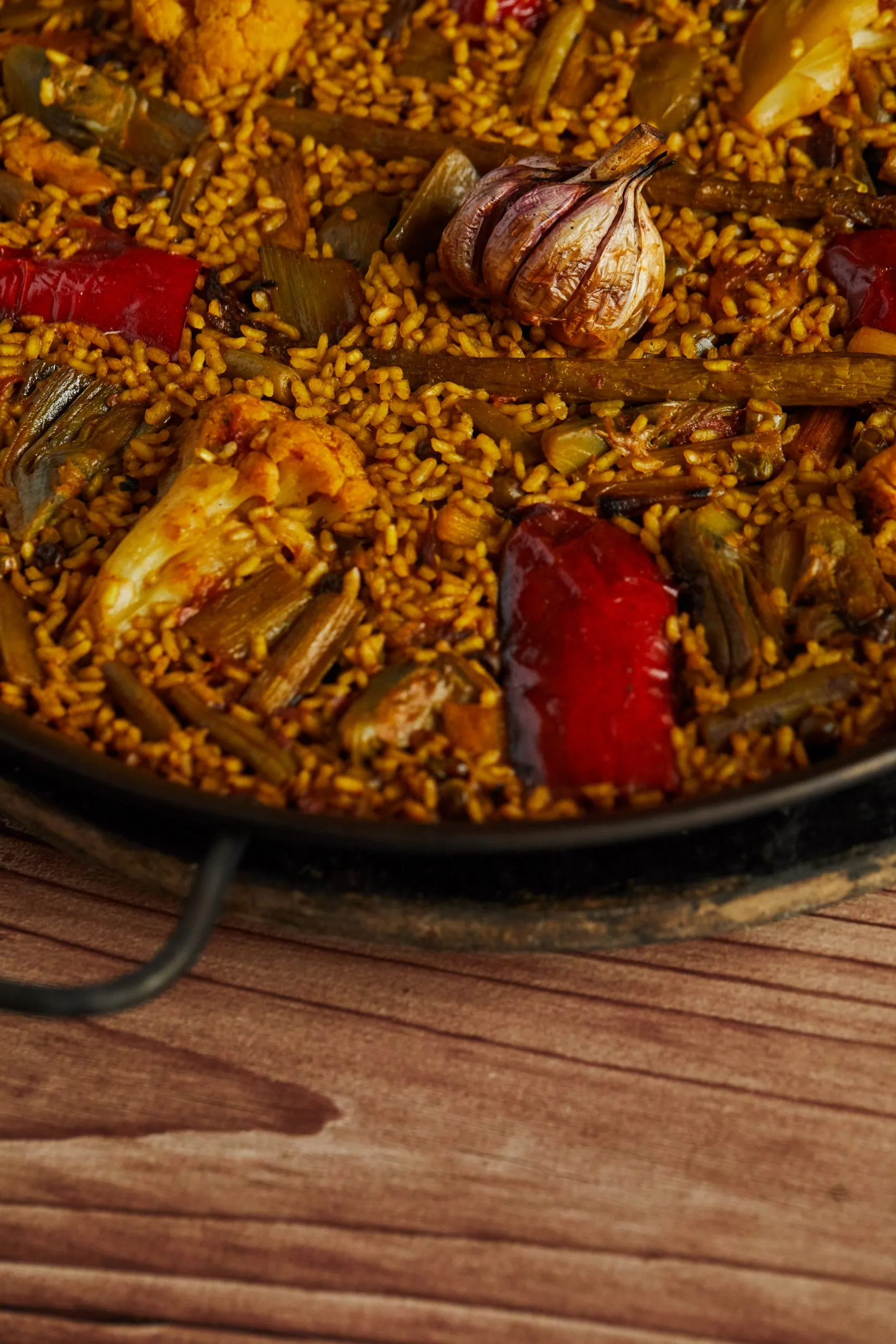Arroz de verduras a la leña con ajos, pimiento rojo, alcachofas y coliflor