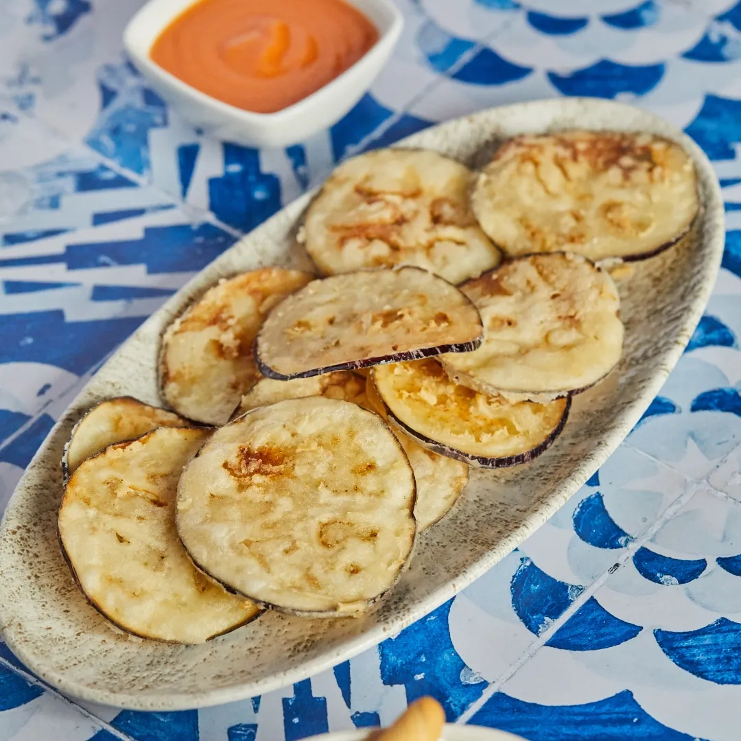 Berenjenas fritas con salmorejo sobre mantel de azulejo